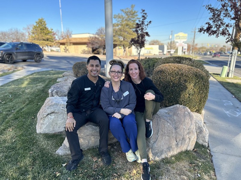 Dental Hygienist team sitting on top of a stone bench